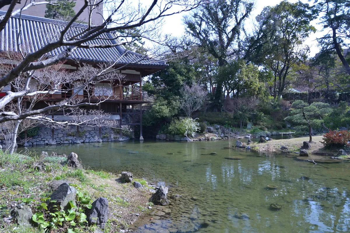 Kokura Castle rising above the moat with cherry blossoms in Kitakyushu, Japan
