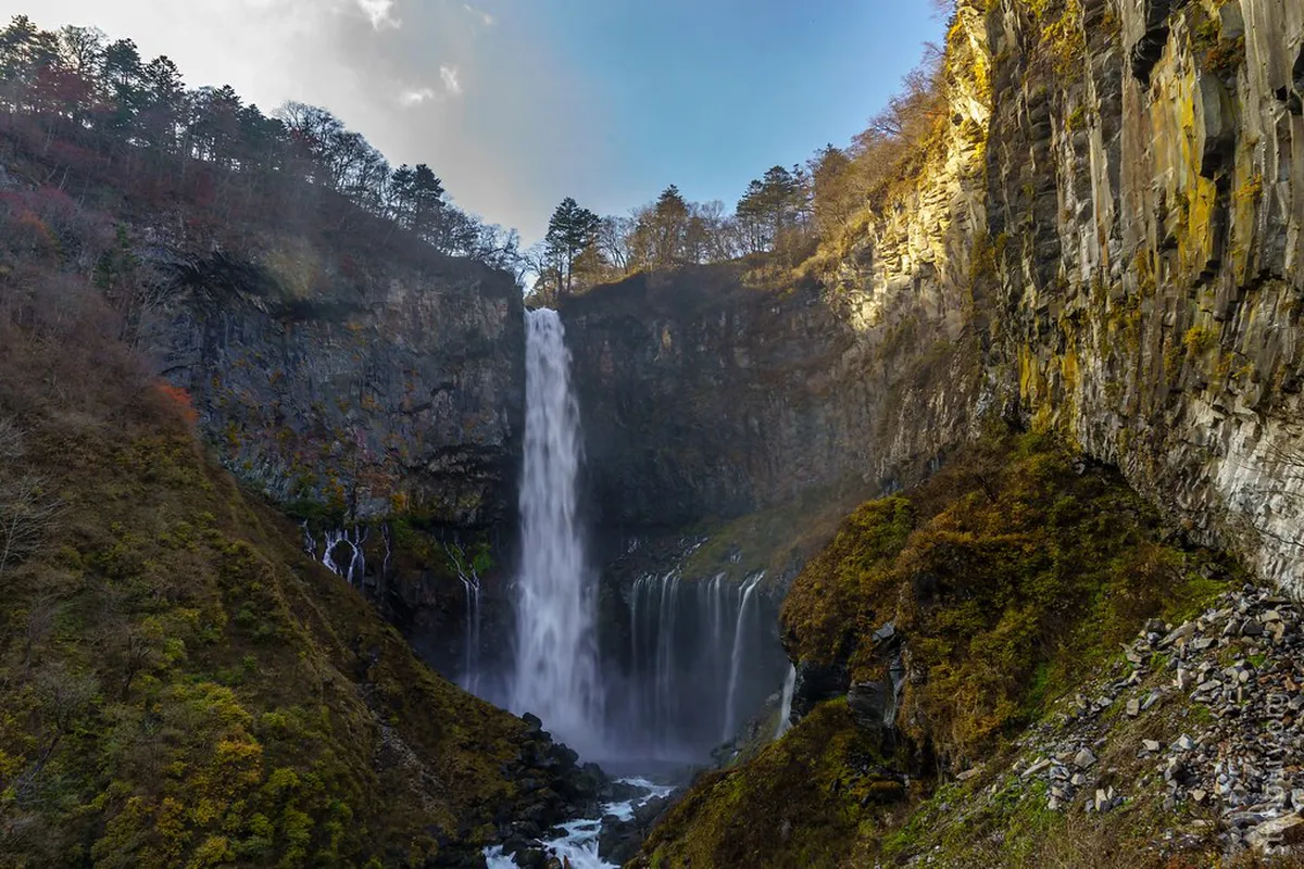 Kegon Falls plunging 97 meters into the gorge below surrounded by forested cliffs in Nikko, Japan