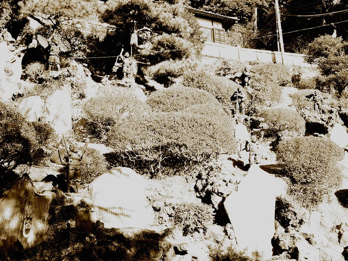 Bronze Tengu statues lining the stone steps leading up to Hansobo Shrine behind Kenchoji Temple in Kamakura, Japan