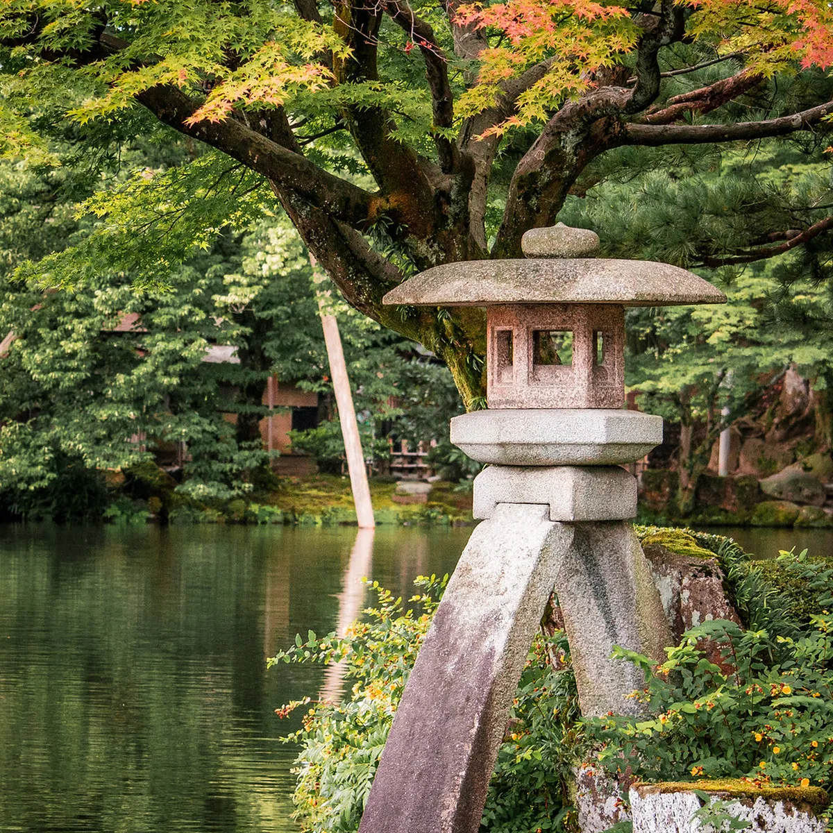 Iconic two-legged Kotoji-toro stone lantern reflected in Kasumigaike pond at Kenrokuen Garden in Kanazawa, Japan