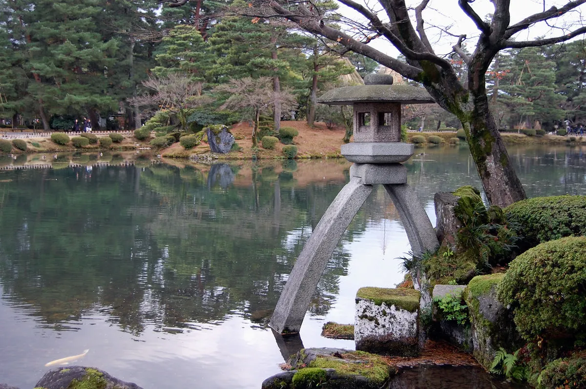The iconic two-legged Kotoji-toro stone lantern reflected in Kasumiga-ike Pond at Kenrokuen Garden in Kanazawa