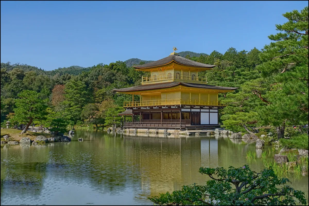 Kinkaku-ji Golden Pavilion gold leaf exterior gleaming above the Mirror Pond in Kyoto on a clear day