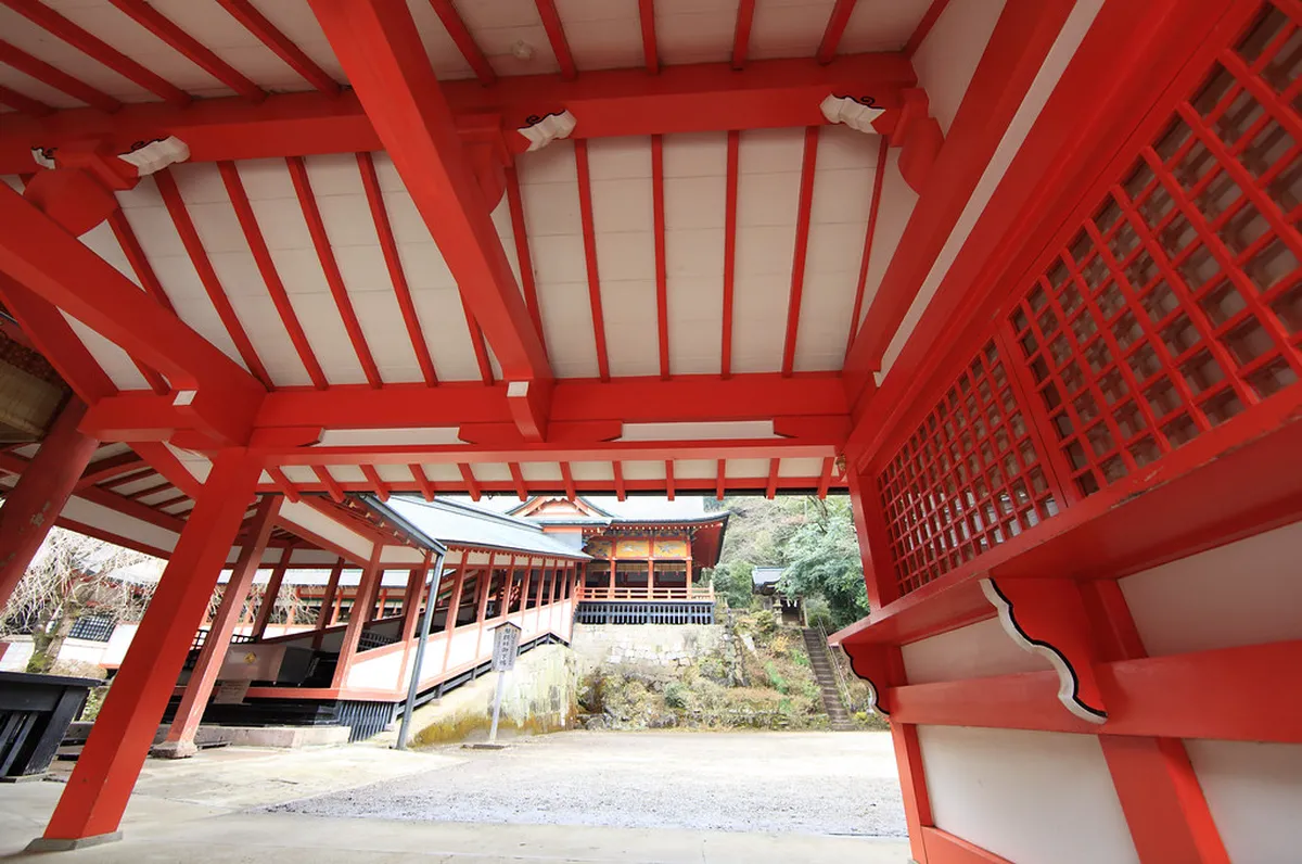 Kirishima Jingu shrine entrance torii gate and stone lanterns set among towering cedar forest in Kagoshima Japan