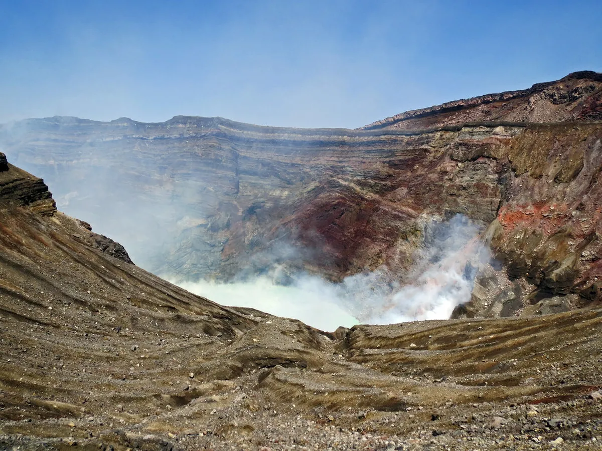 Mount Aso active crater with turquoise lake and volcanic steam venting in Kumamoto, Japan