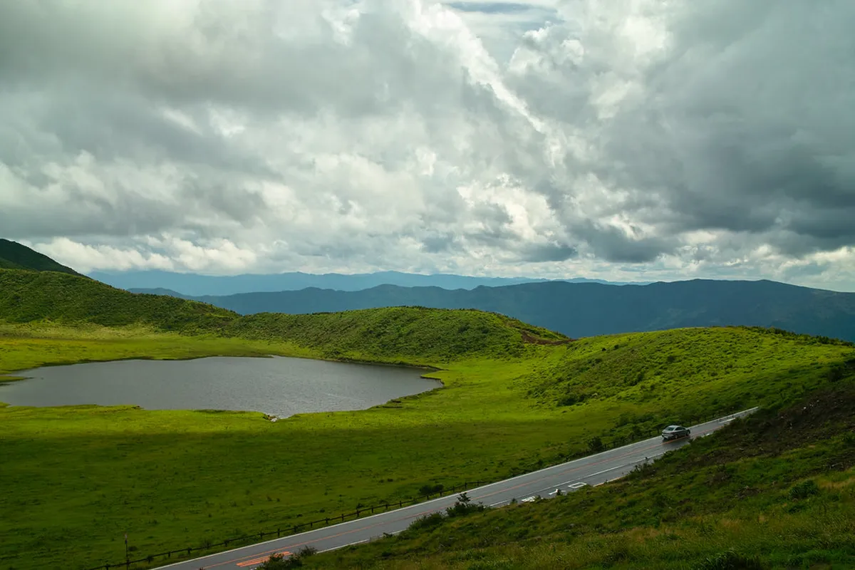 Mount Aso caldera and Kusasenri grassland plateau with volcanic peaks in the background in Kumamoto, Japan