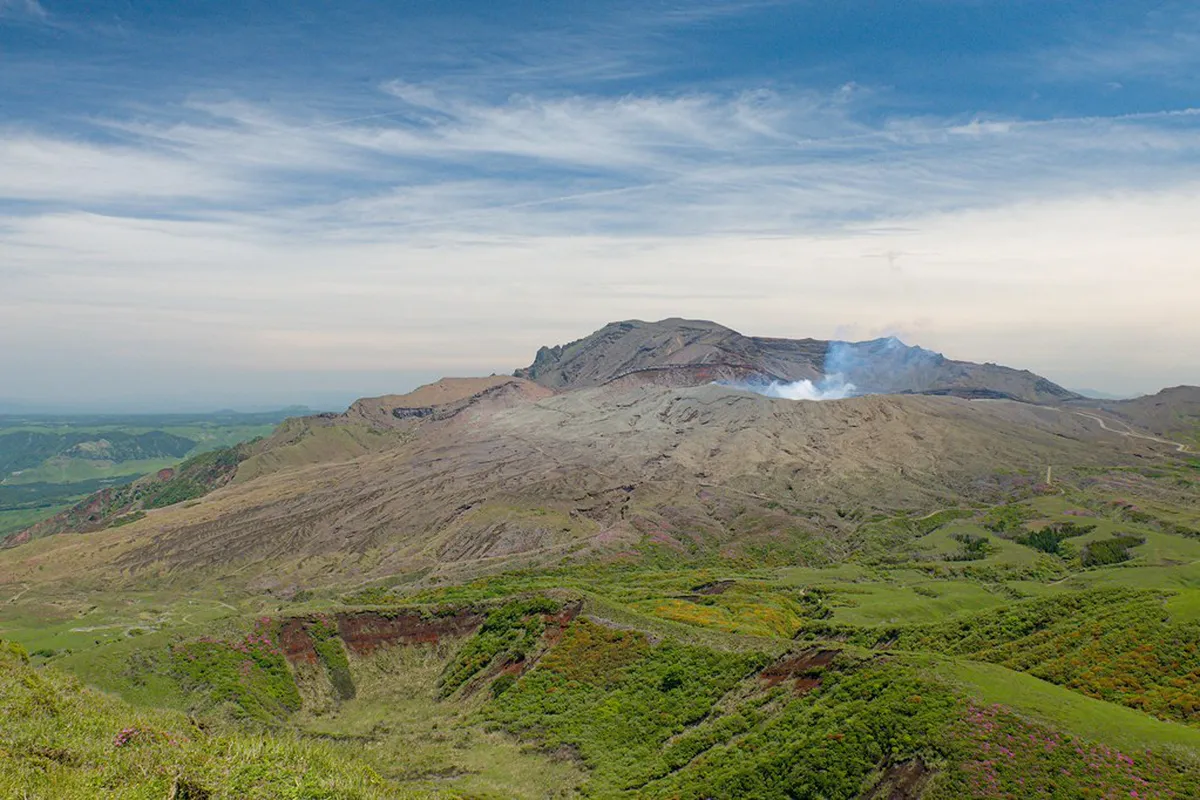 Mount Aso caldera with steam rising from the active Nakadake crater on a clear day in Kumamoto, Japan