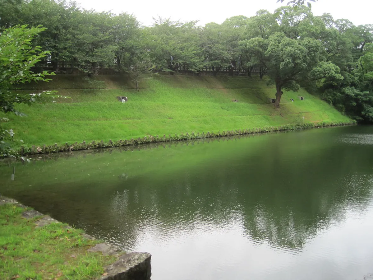 Kumamoto Castle rising above lush park grounds and stone walls in Kumamoto, Japan
