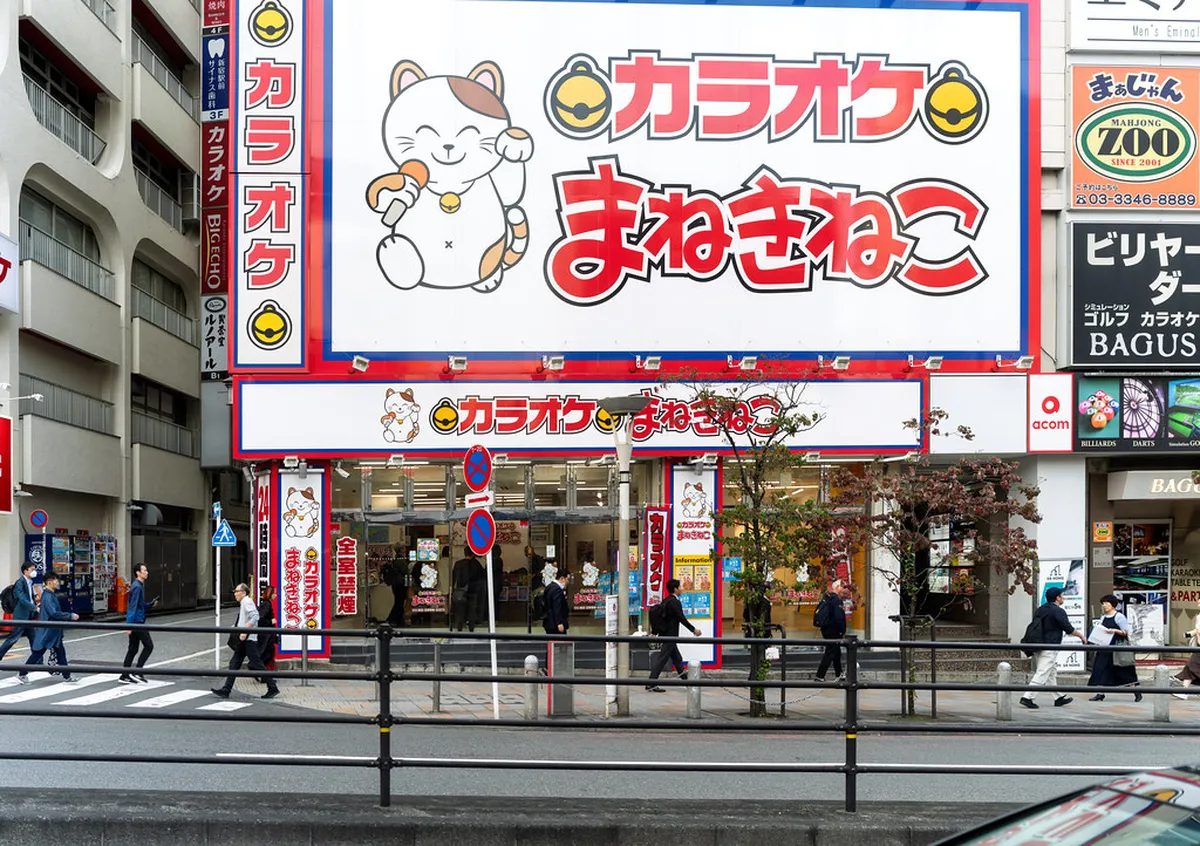 Lively karaoke bar interior in Japan with colorful lights and music screen, a staple of Kumamoto nightlife