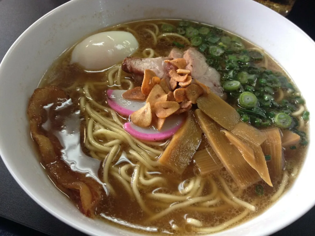 Dark burnt garlic mayu oil swirled into creamy pork broth ramen, the signature flavour of Kumamoto noodle shops in Japan