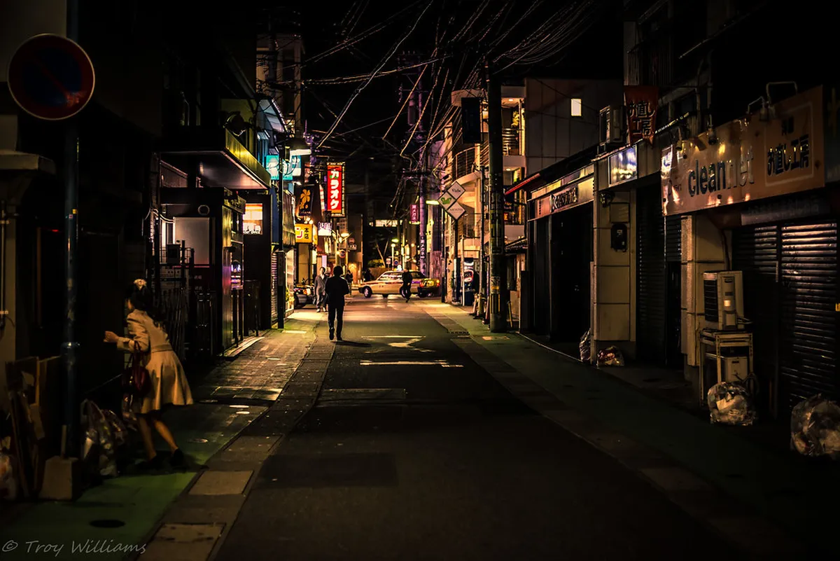 Busy Fukuoka street at night with neon signs and crowds reflecting the city’s energetic modern character in Japan