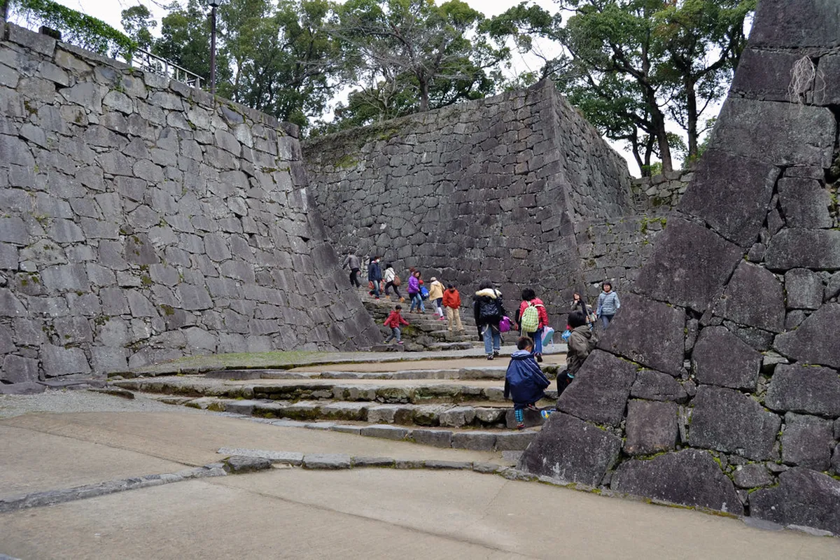 Kumamoto Castle main tower rising above wide stone walls that once defined samurai power in Kyushu, Japan
