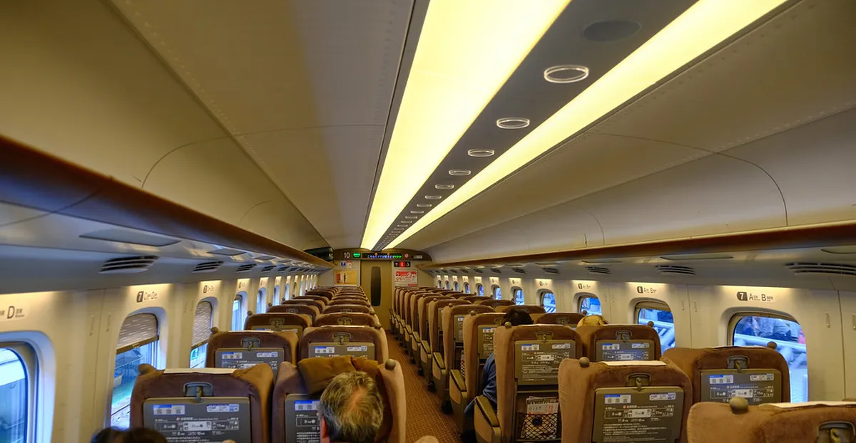 Shinkansen bullet train speeding through Kyushu countryside connecting Fukuoka and Kumamoto in just 30 minutes