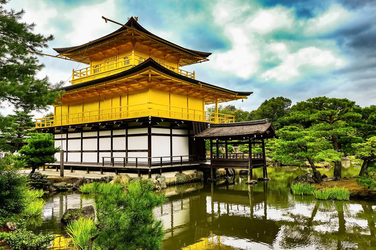 Kinkaku-ji Golden Pavilion temple covered in gold leaf perfectly reflected on the calm mirror pond in Kyoto, Japan
