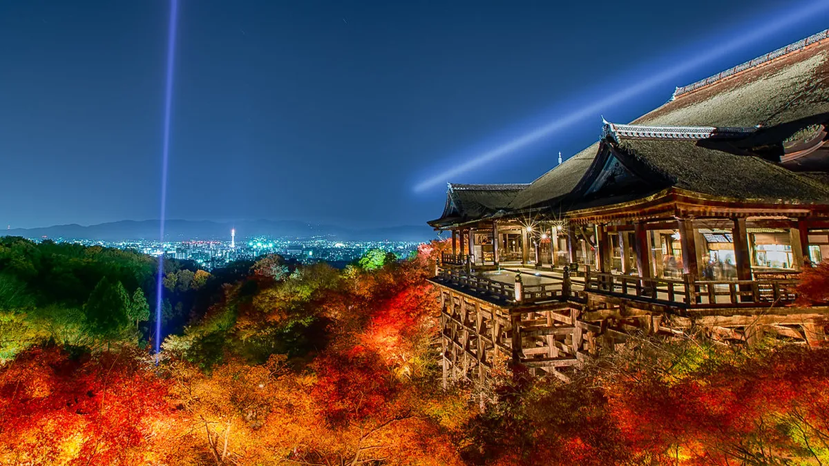 Kiyomizu-dera Temple wooden stage jutting out from the hillside over the treetops with a panoramic view of Kyoto, Japan