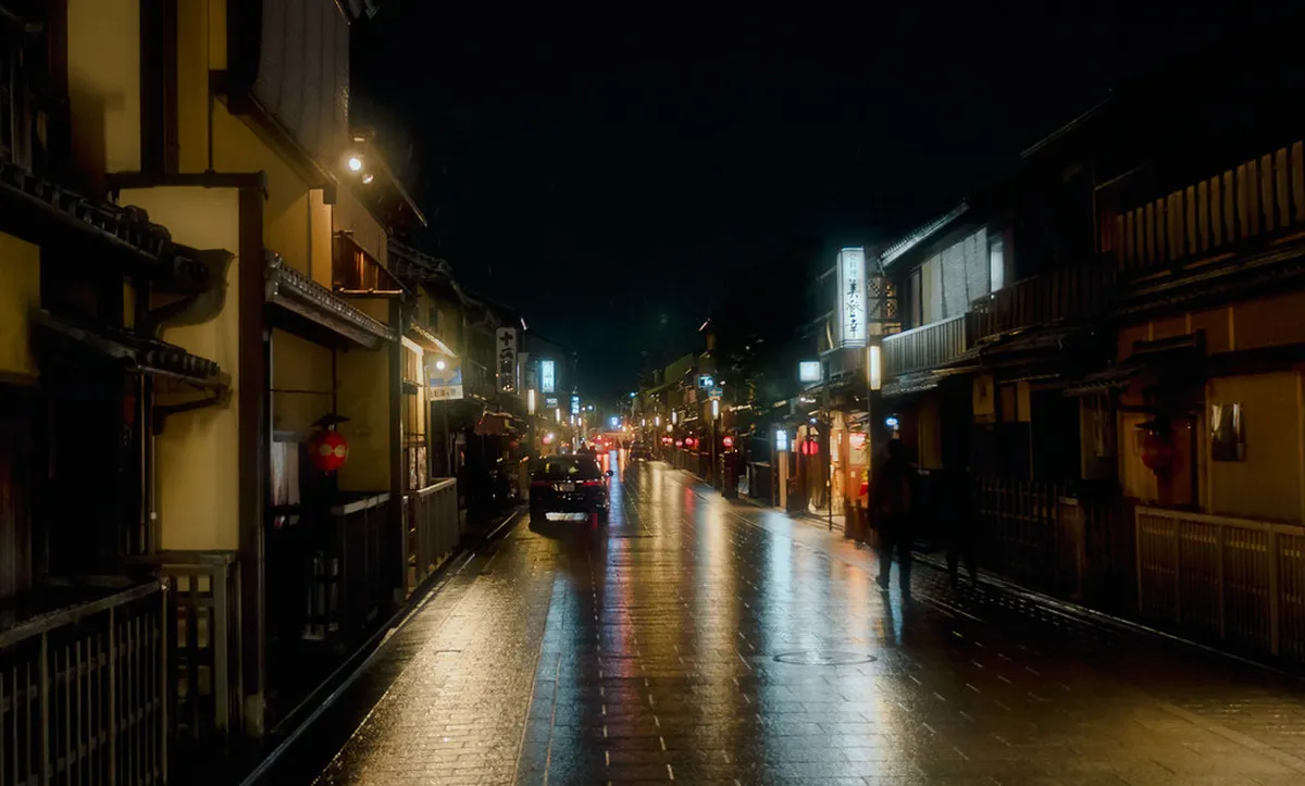 Softly glowing lanterns illuminating the traditional machiya-lined streets of Kyoto’s Gion district at night in Japan