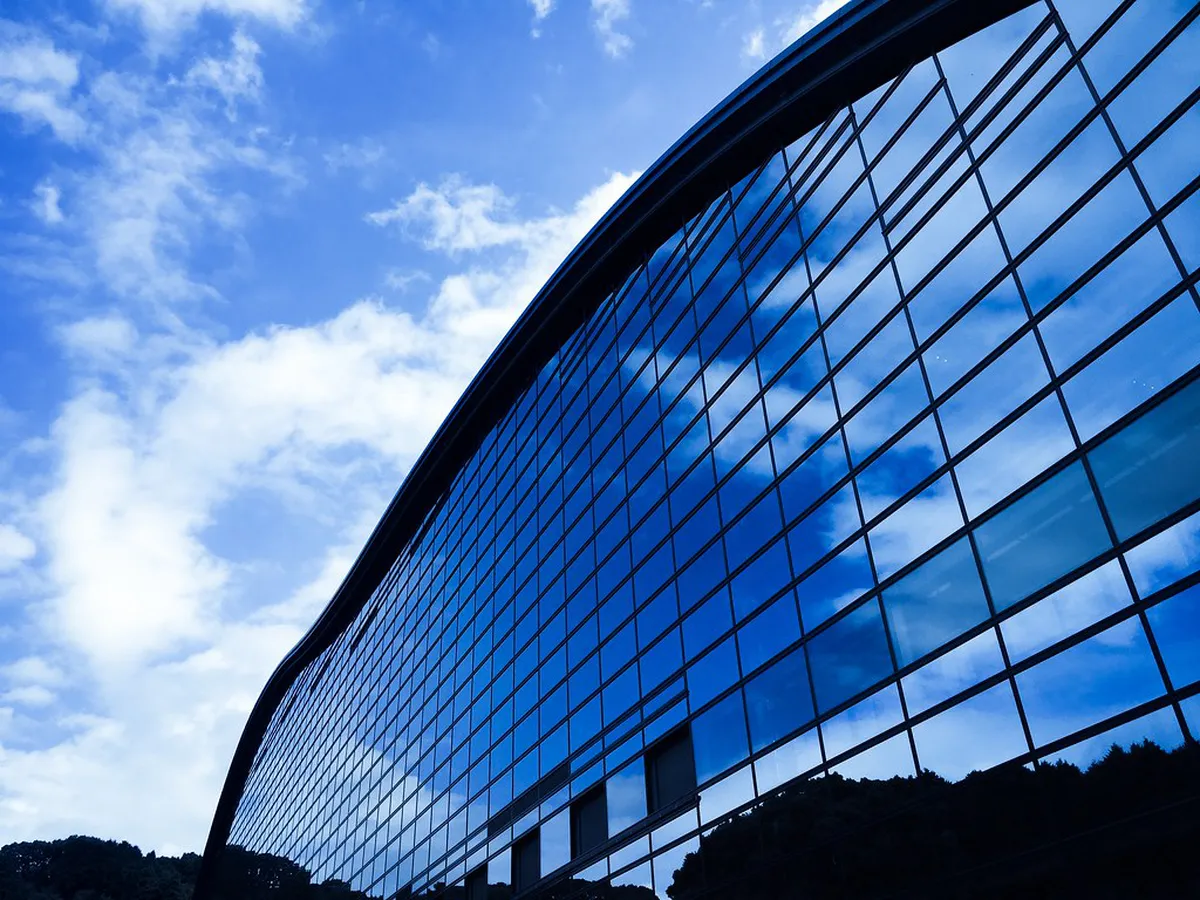 Striking wave-like blue glass facade of the Kyushu National Museum building nestled among the hills of Dazaifu, Japan