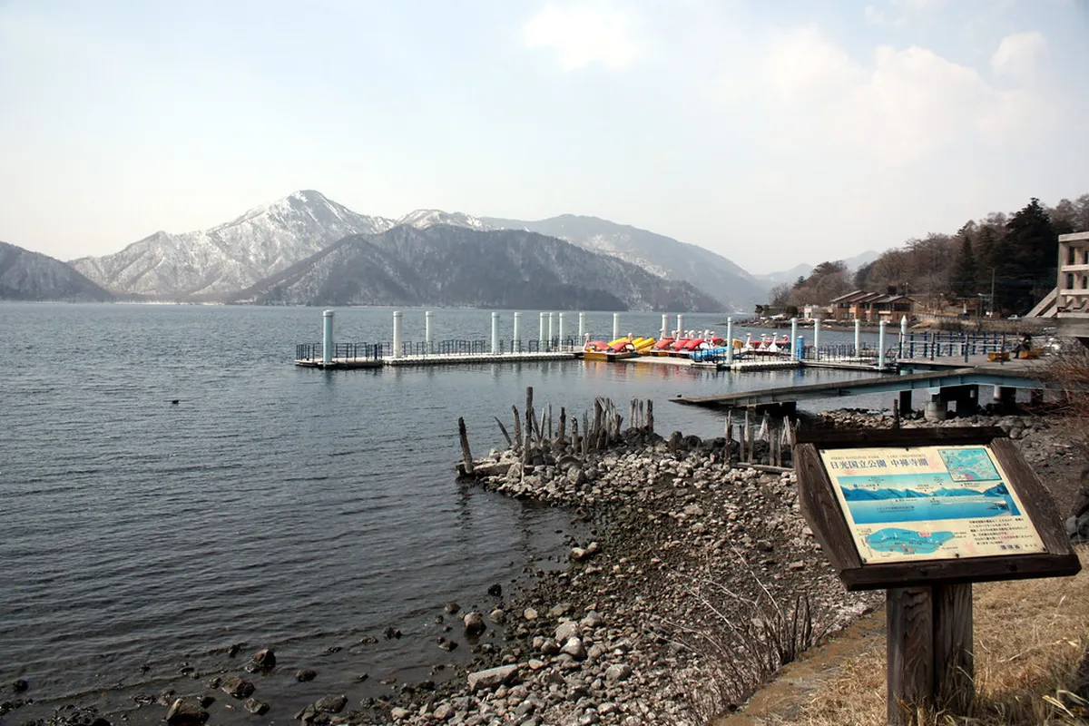Lake Chuzenji mountain panorama with forested slopes and clear alpine skies in Nikko, Japan