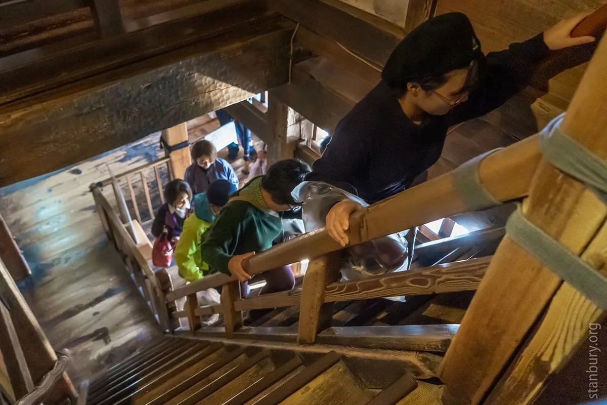 Inside Matsumoto Castle's original wooden interior with steep narrow staircases leading up through the six-storey keep in Nagano