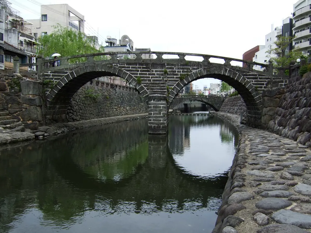 Megane Bridge double stone arch spanning the Nakashima River in central Nagasaki, Japan, viewed from the riverside embankment
