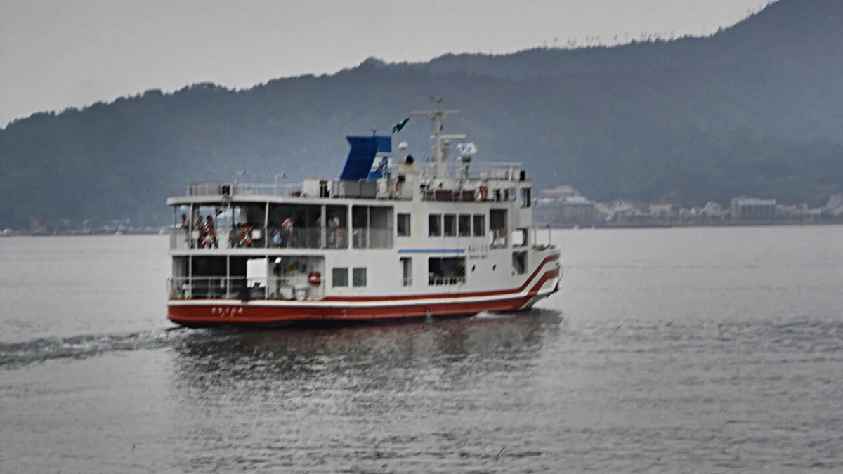 Ferry crossing the Seto Inland Sea toward Miyajima Island with the torii gate visible in the distance, Hiroshima, Japan