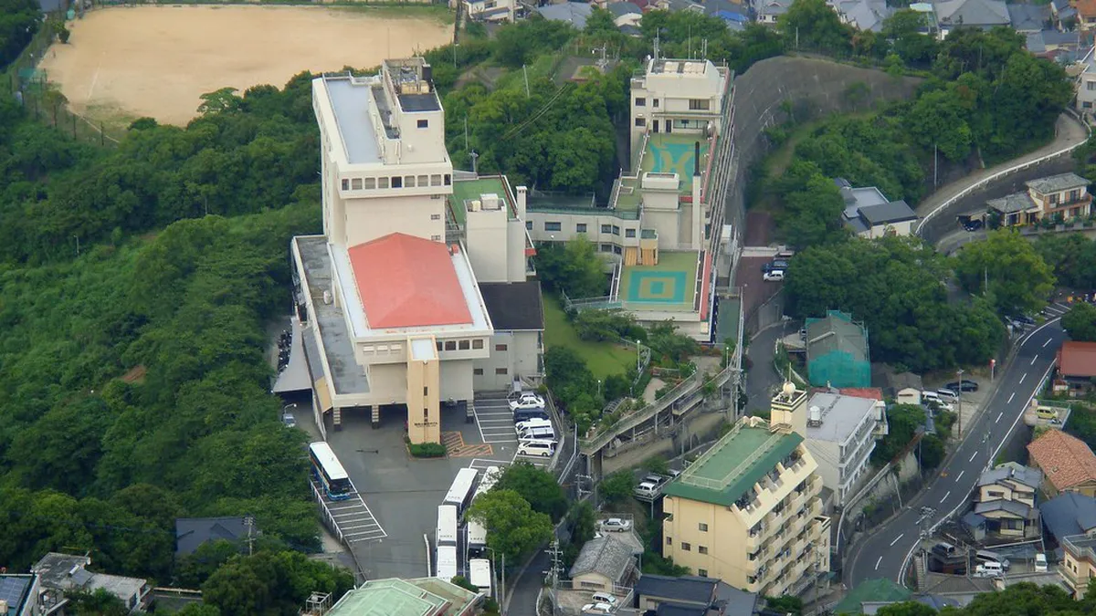 Nagasaki ropeway gondola ascending Mount Inasa above city rooftops with harbor views below, Japan