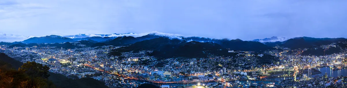 Mount Inasa observation platform with panoramic glass walls overlooking Nagasaki harbor at night, Japan
