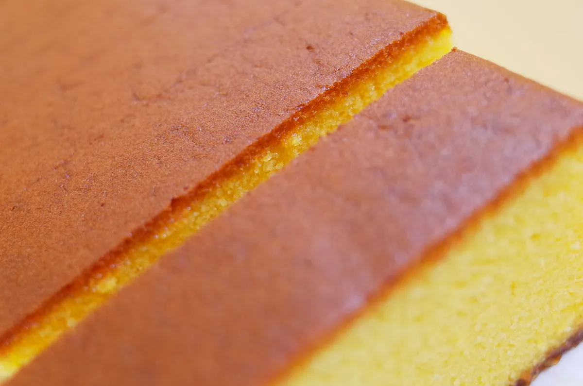 Traditional Nagasaki castella sponge cake sliced to show the golden crumb and zarame sugar base, Japan