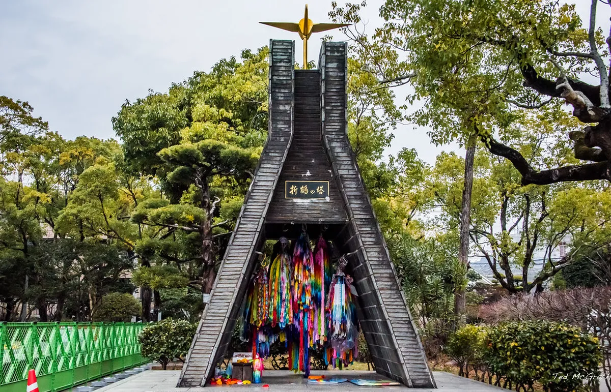 Colorful paper cranes and origami offerings at Nagasaki Peace Park symbolizing hope and remembrance for atomic bomb victims in Japan