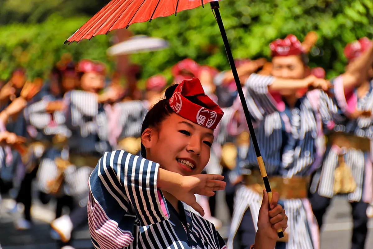 Performers dressed in full samurai armor marching through city streets during a traditional Japanese festival parade