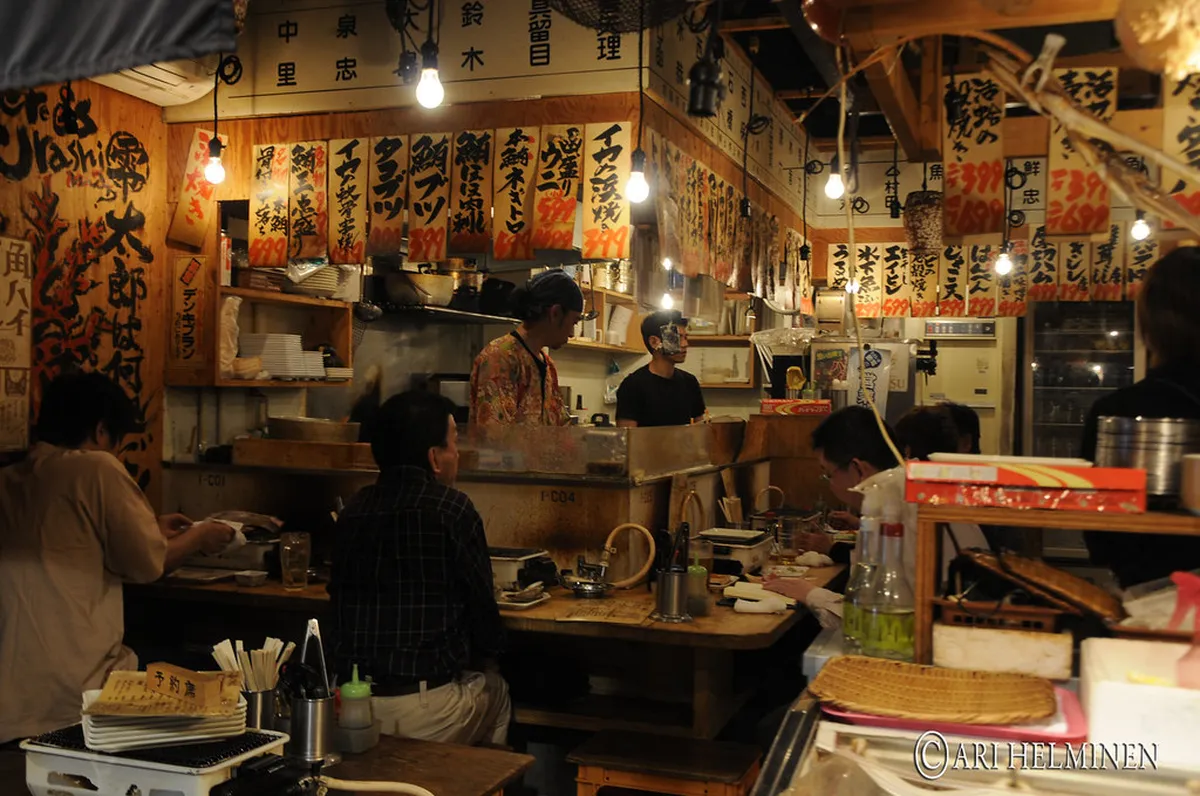 An intimate cocktail bar interior with warm lighting and craft drinks on the counter, representing the upscale bar scene in Nagoya, Japan