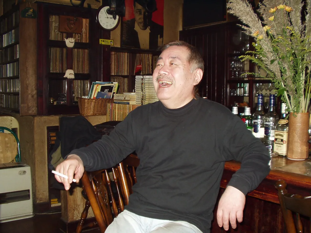 A jazz musician performing on stage in a dimly lit club, representing Nagoya's thriving live music scene in Japan