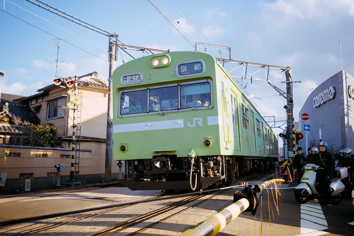 A JR Nara Line train at a station platform in Japan, ready to depart on the route connecting Nara and Kyoto