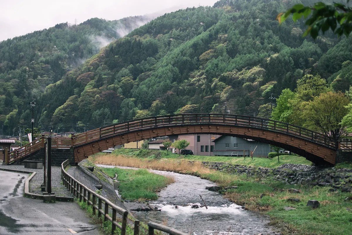 The restored wooden Kiso-no-Ohashi bridge spanning the river near Narai-juku post town in the Kiso Valley, Nagano, Japan