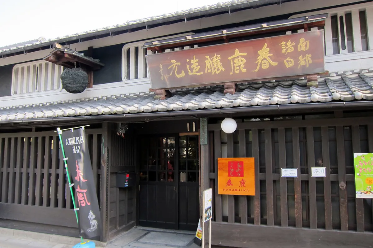 Traditional machiya townhouses with wooden lattice facades lining a narrow alley in Naramachi, Nara, Japan