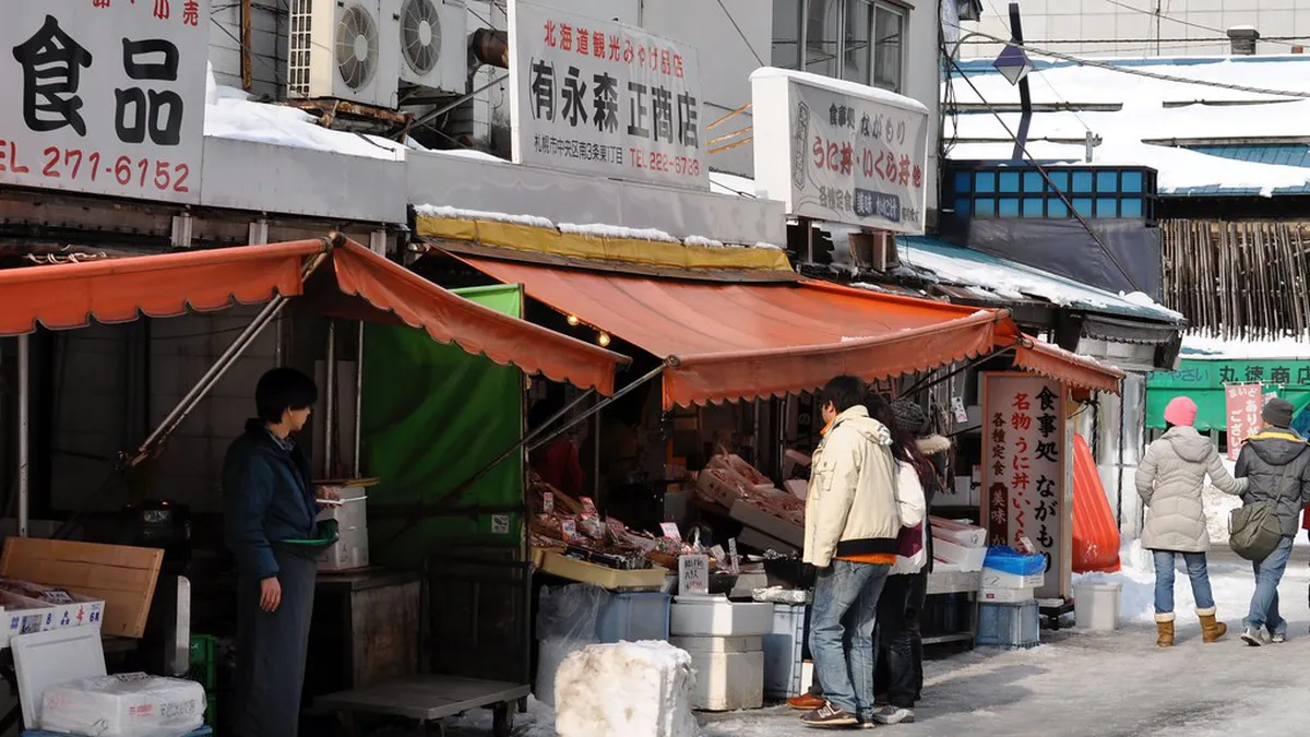 Nijo Market arcade covered walkway with colorful fish market stalls and vendors in central Sapporo Japan