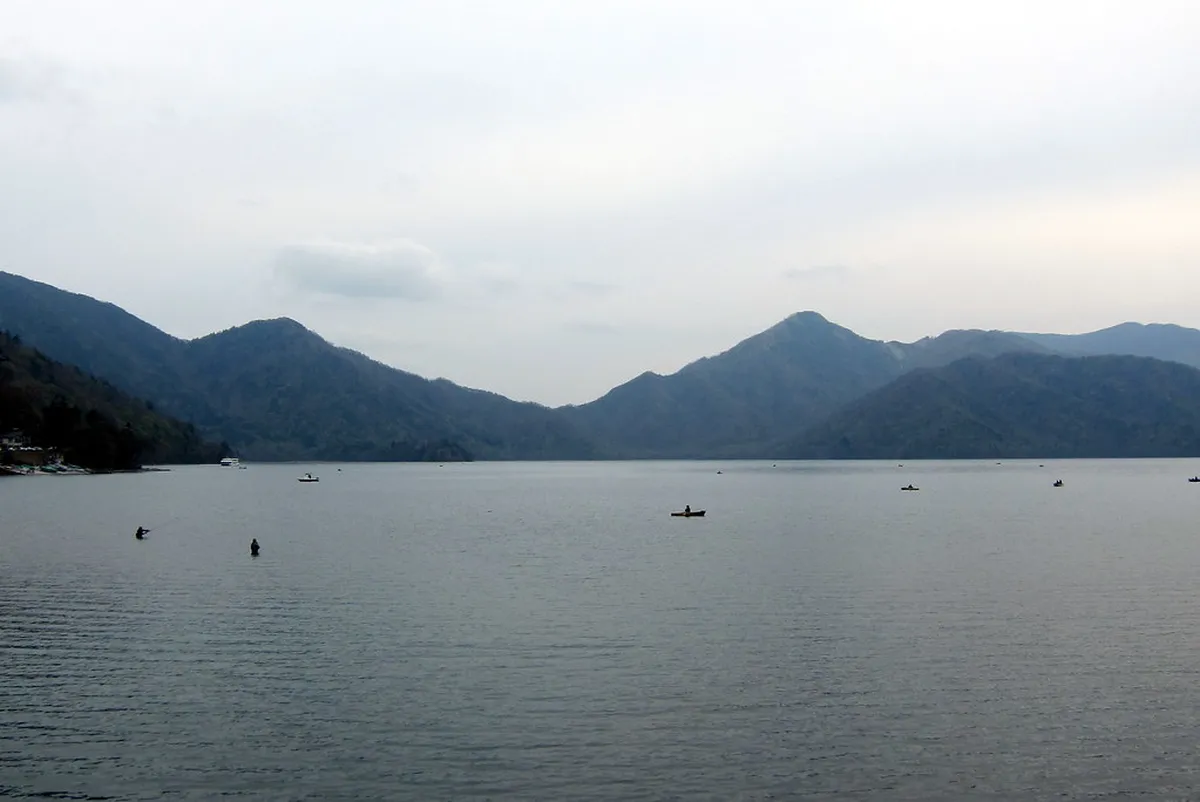 Scenic hiking path along the shores of Lake Chuzenji with Mount Nantai visible in Nikko, Japan