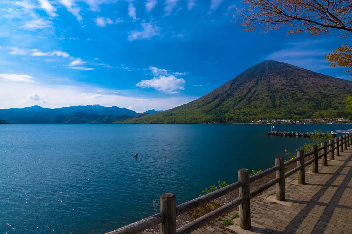The calm lakeside promenade along Lake Chuzenji in Nikko, Japan, with mountain scenery in the background