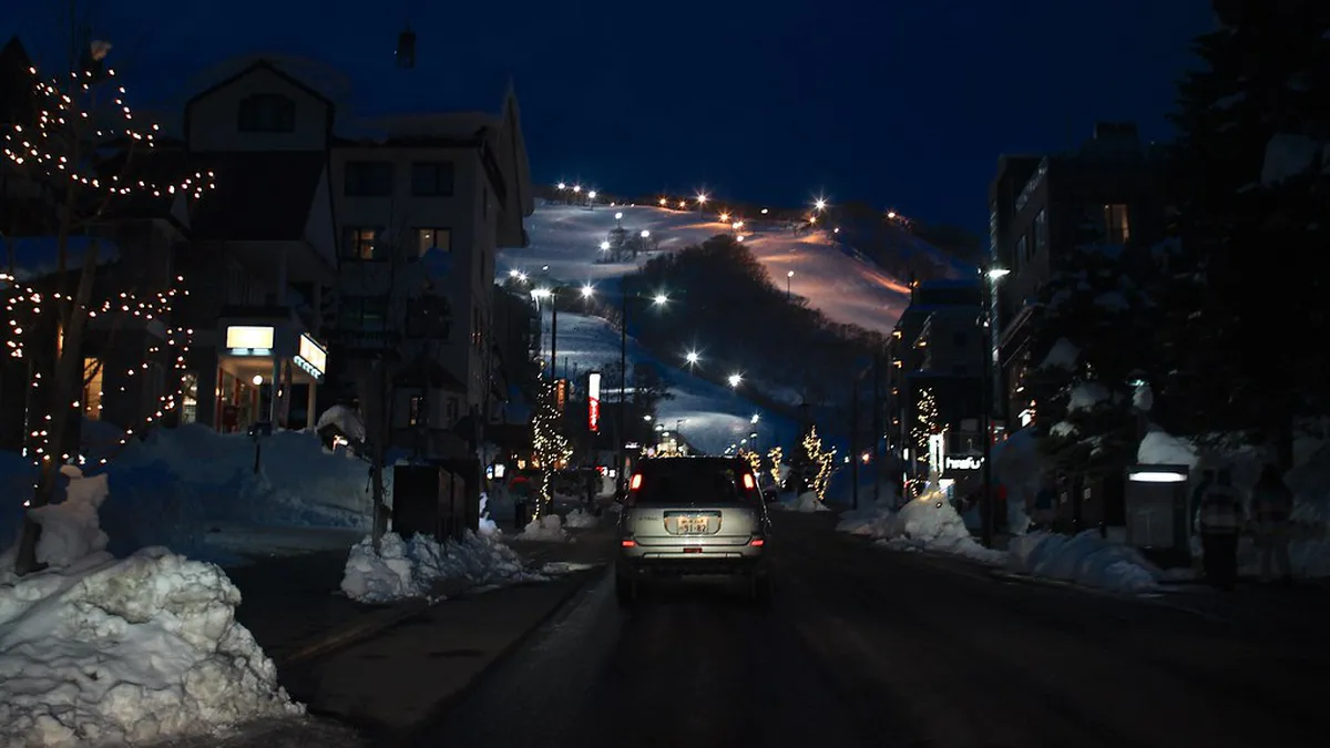 Niseko Hirafu village illuminated at night with snow-covered streets and warm restaurant lights in Japan