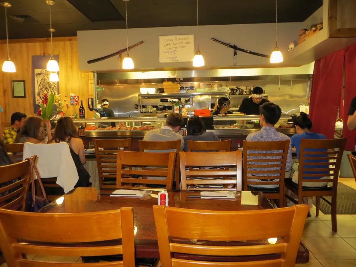 Cosy interior of a Japanese izakaya bar with warm lighting, sake bottles and bar counter in Japan