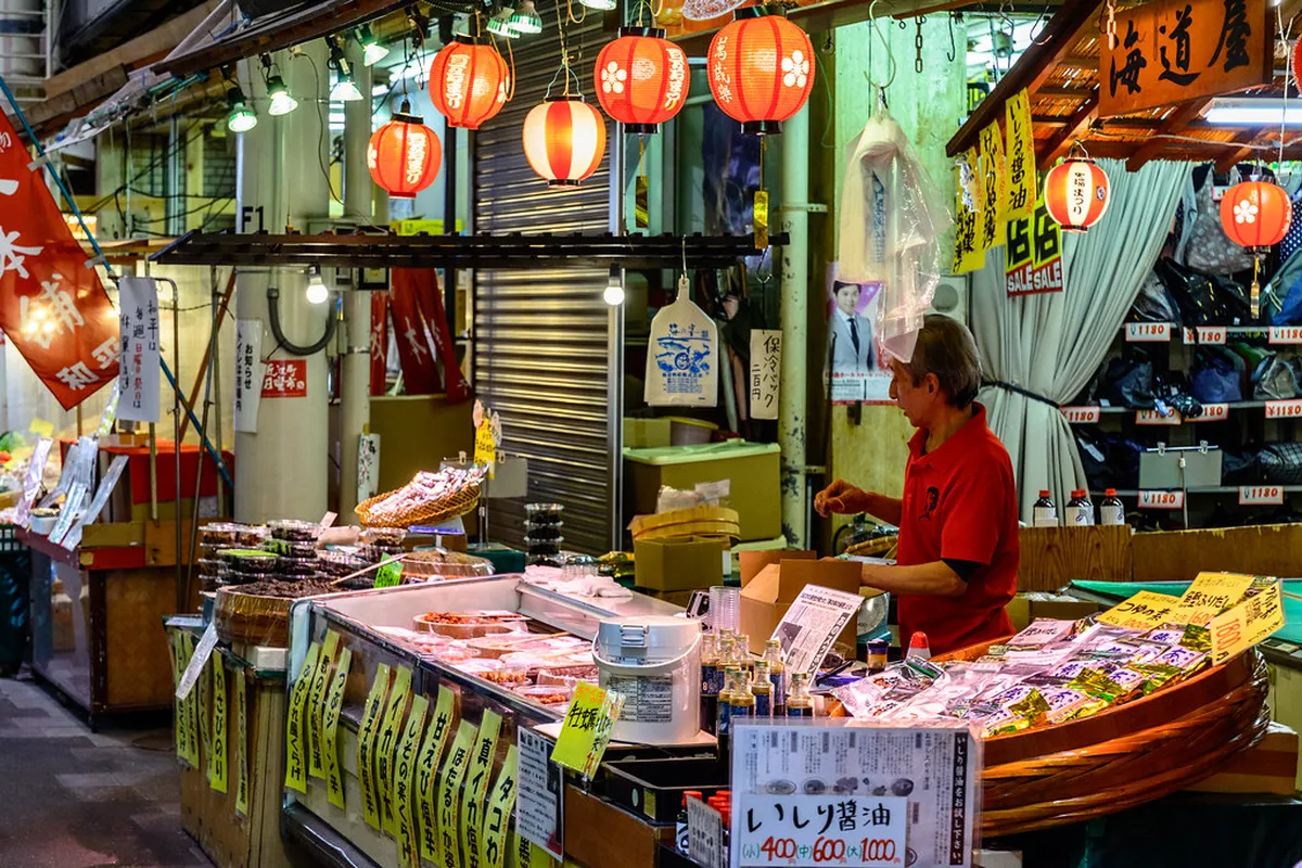 Covered arcade walkway lined with fresh produce and seafood stalls inside Omicho Market in Kanazawa