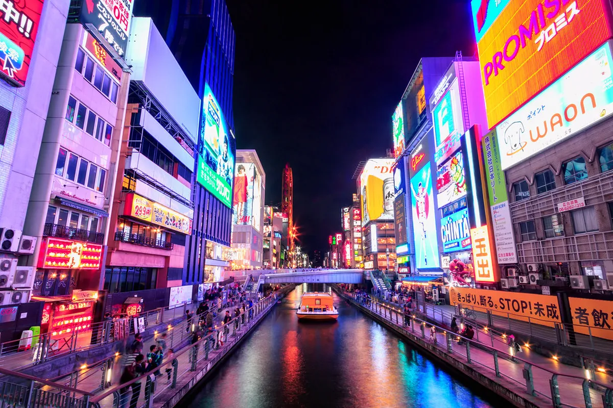 Neon lights and glowing signs reflecting off the Dotonbori canal in Osaka Japan after dark
