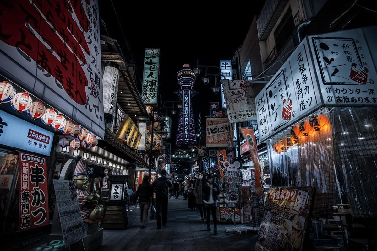 Tsutenkaku Tower and colorful Shinsekai district street at night in Osaka Japan