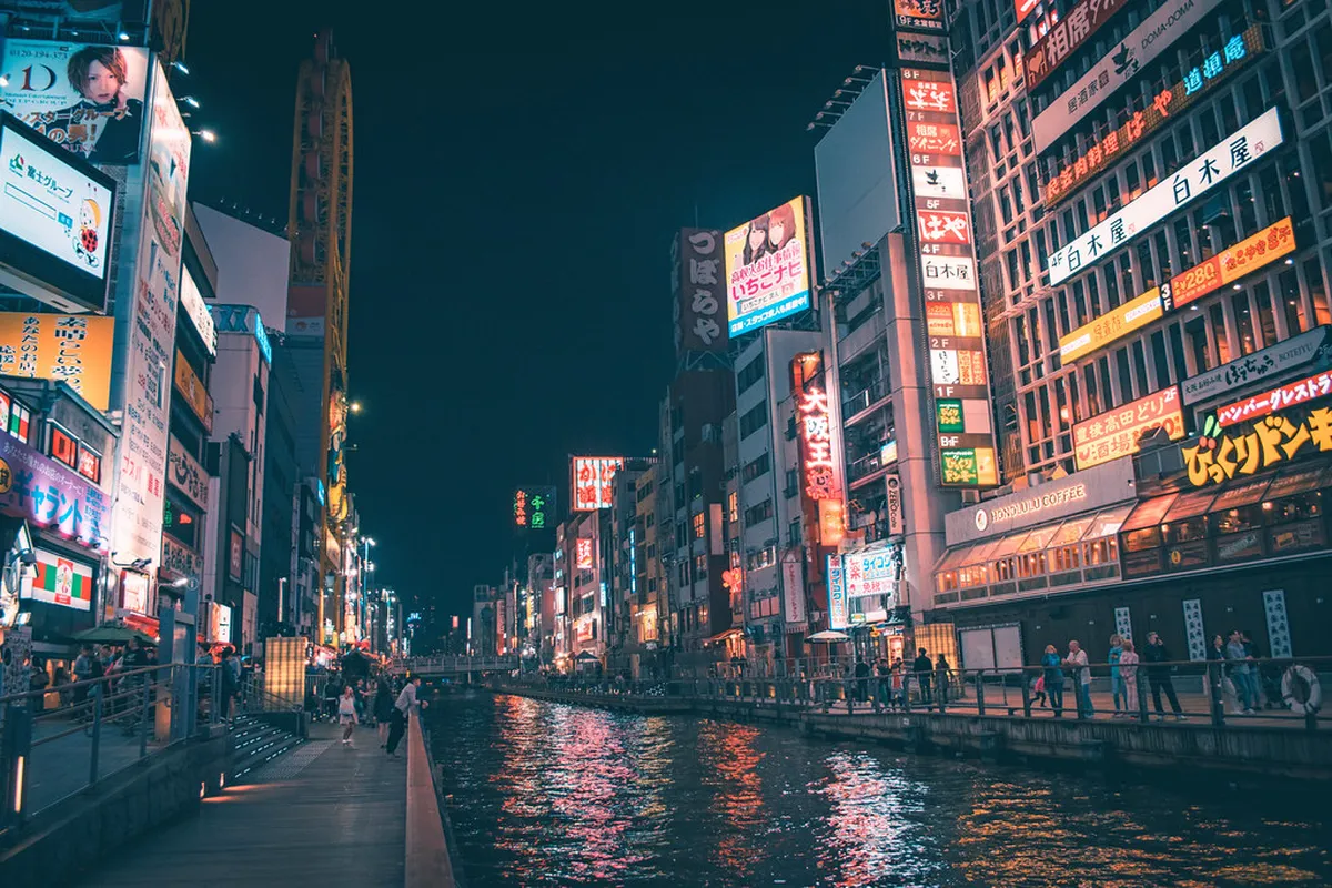 Dotonbori canal at night with glowing neon signs and the famous Glico Running Man billboard in Osaka, Japan