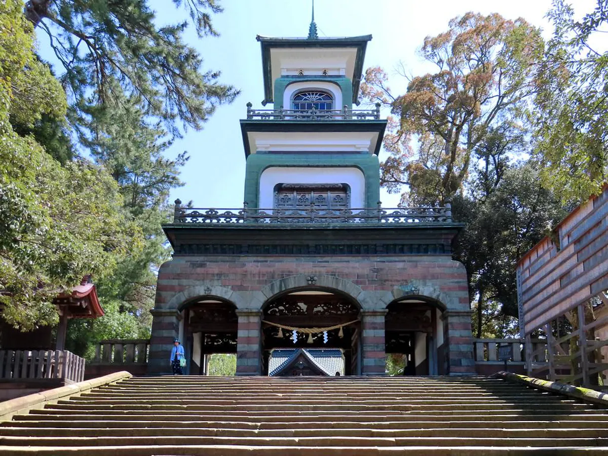 The eclectic three-story Shinmon gate at Oyama Shrine in Kanazawa blending Romanesque stone, Chinese carvings, and Dutch stained glass panels