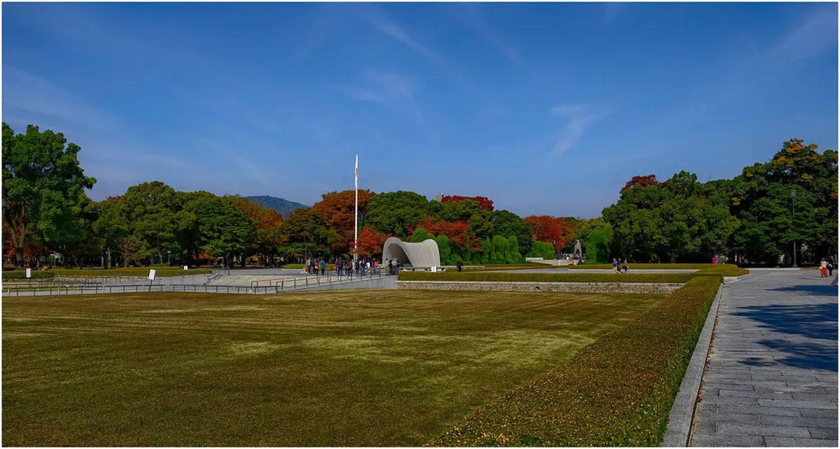 Hiroshima Peace Memorial Park cenotaph arch framing the Atomic Bomb Dome across the Pond of Peace in Japan