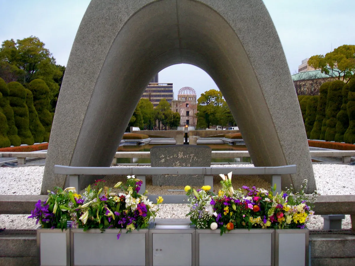 Flame of Peace burning at Hiroshima Peace Memorial Park with the Atomic Bomb Dome visible on the horizon in Japan