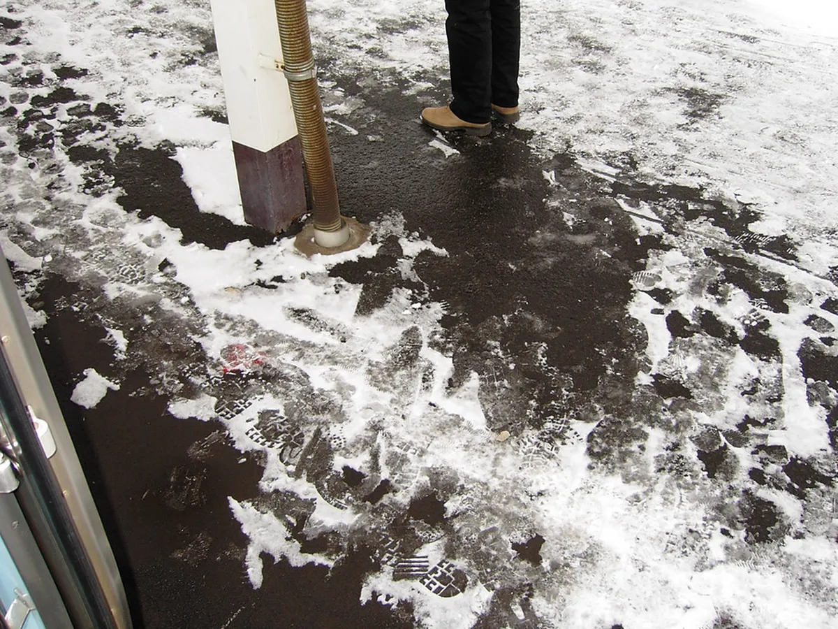 Sapporo JR train station exterior in winter with snow on the ground and commuters bundled up in Japan