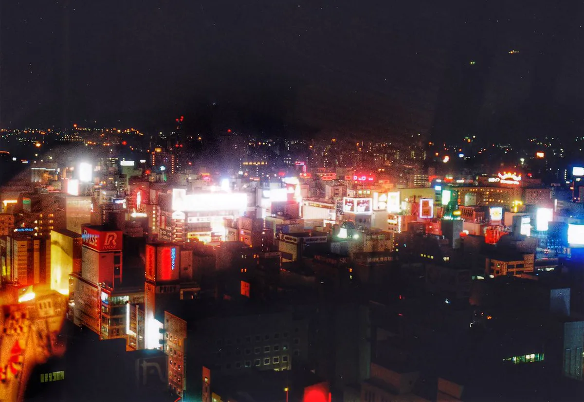 Sapporo TV Tower illuminated at night with city lights and the glow of Odori Park visible below in Hokkaido Japan