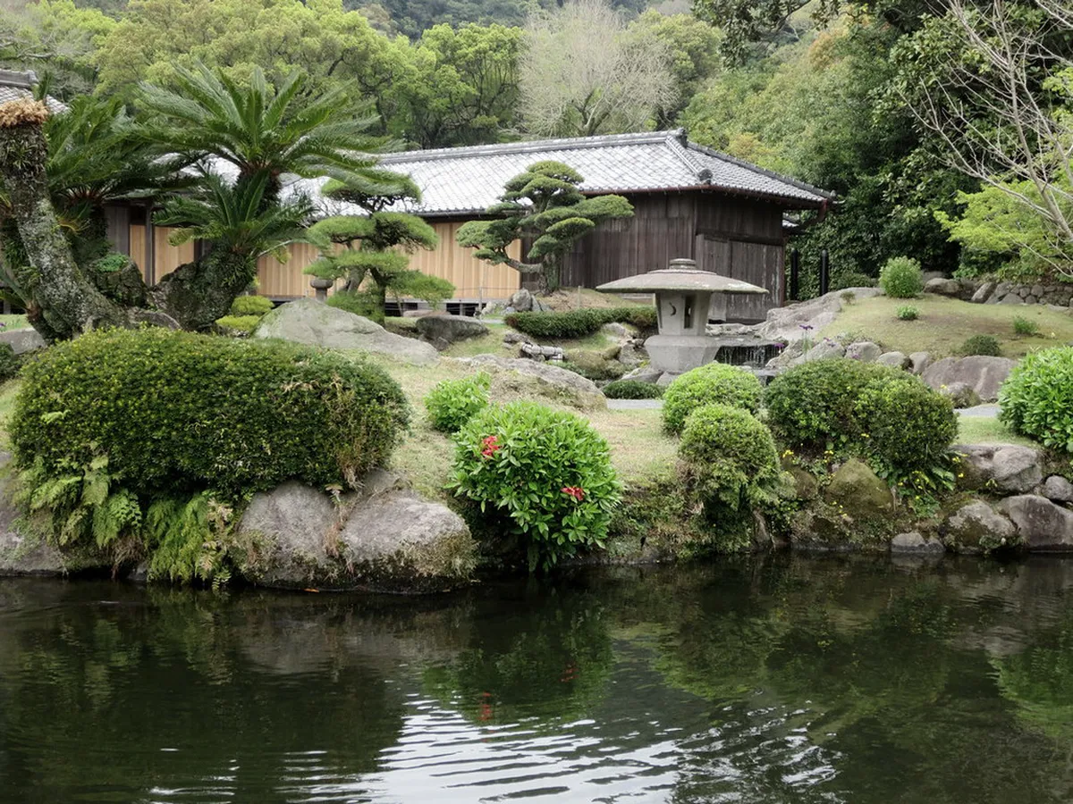 Sengan-en garden in Kagoshima with traditional stone lanterns and Sakurajima volcano visible across Kinko Bay