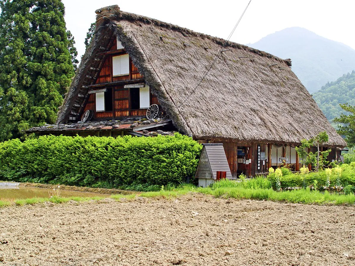 Spring morning in Shirakawa-go with gassho farmhouses reflected in flooded rice paddies, clear blue sky